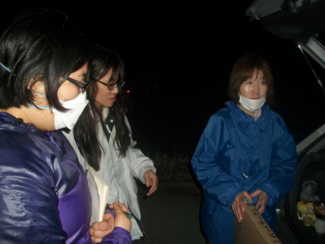 Japanese rescuers during night-time meeting